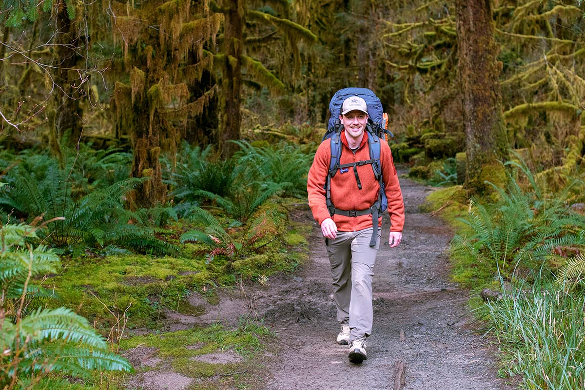Hiking down trail wearing Arc'teryx Covert Cardigan fleece jacket